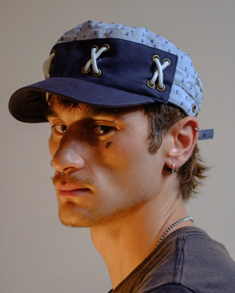Navy cap laced with white cord through the grommets